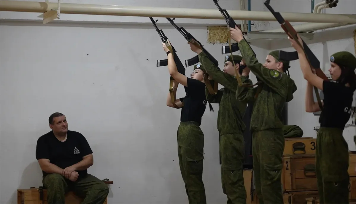 Sergey Terekhov with his students during the classes in “Sarma”. <a href="https://www.youtube.com/watch?v=NjrPBmXX3vo" rel="noopener noreferrer" title="https://www.youtube.com/watch?v=NjrPBmXX3vo">A shot from the film “Firewood for the mobilised”</a>
