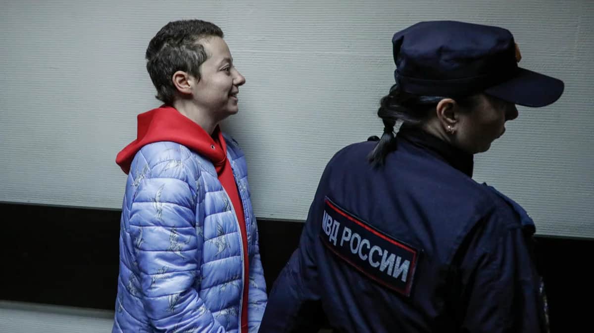 Сотрудник полиции сопровождает театрального режиссера Евгению Беркович во время слушаний по уголовному делу об "оправдании терроризма" в Замоскворецком районном суде Москвы, 5 мая 2023 года. Фото: Юрий Кочетков / EPA-EFE