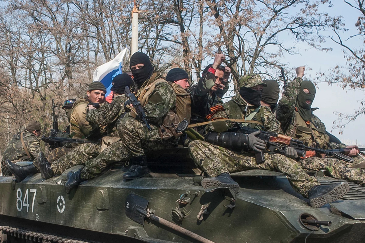 Вооруженные люди передвигаются на бронетранспортере с российским флагом по дороге из Краматорска в Славянск в Донецкой области, 16 апреля 2014 года. Фото: Роман Пилипей / EPA