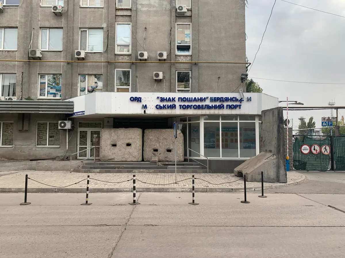 Вывеска торгового порта частично обвалилась после взрывов. Фото: Арден Аркман / специально для «Новой газеты. Европа»