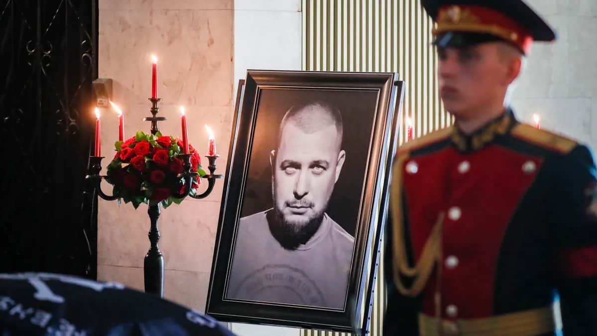 A guard stands next to a portrait of Vladlen Tatarsky at his funeral in Moscow, 8 April 2023. Photo: EPA-EFE/YURI KOCHETKOV