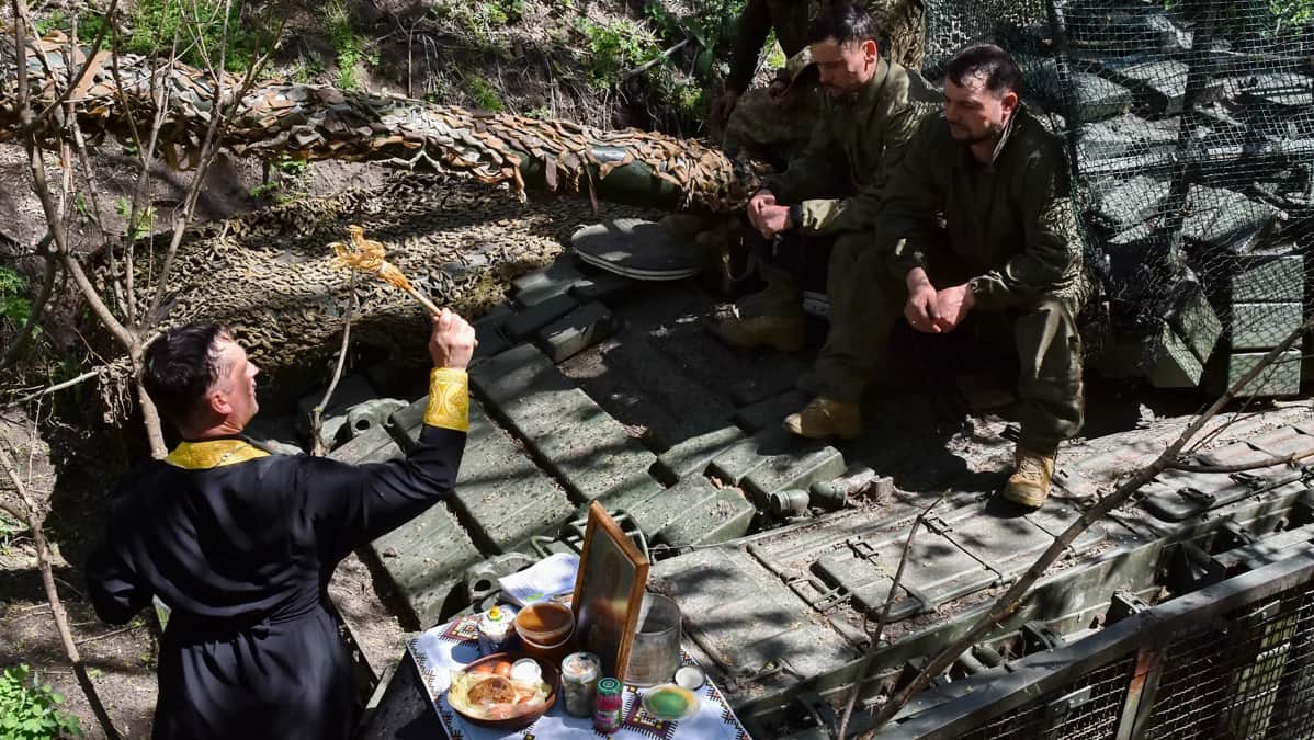 Военный капеллан Сергей проводит службу возле танка и его экипажа во время празднования Пасхи вблизи линии фронта в Запорожской области, Украина, 20 апреля 2025 года. Фото: пресс-служба 65-й отдельной механизированной бригады ВСУ / EPA