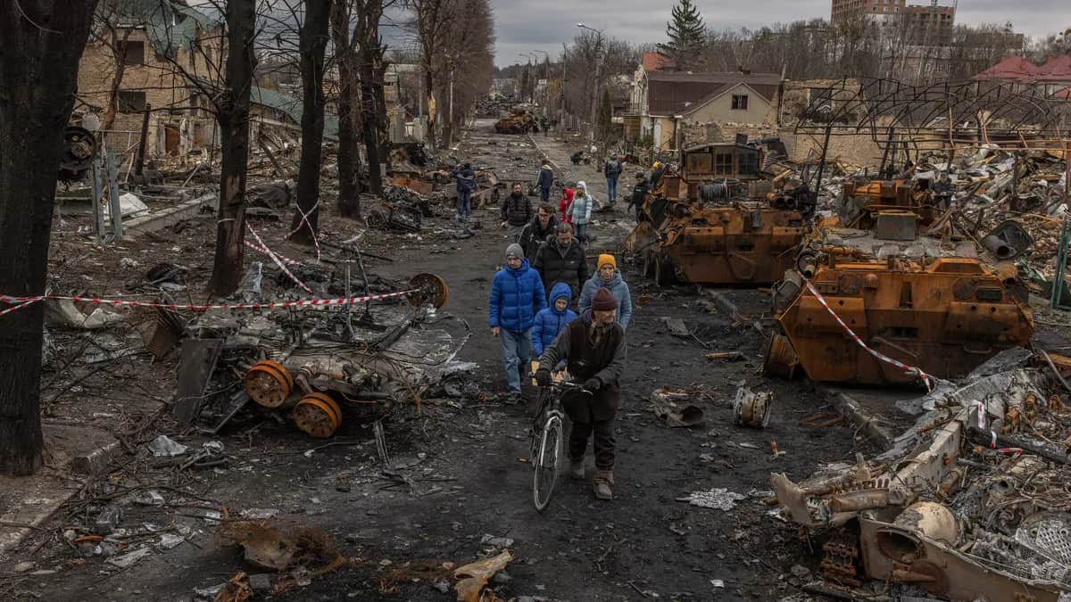 Residents walk past the wreckage of dozens of Russian military vehicles in the town of Bucha following a brutal month-long occupation in which hundreds of Ukrainian civilians were tortured and killed, 6 April 2022. Photo: EPA-EFE/ROMAN PILIPEY