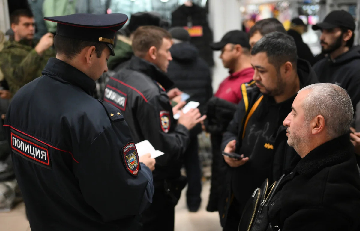 Полицейские проверяют документы сотрудников торгового центра во время рейда по выявлению нарушителей миграционного законодательства и правил воинского учёта в Новосибирске, 15 октября 2024 года. Фото: Александр Кряжев / Спутник / Imago Images / Scanpix / LETA