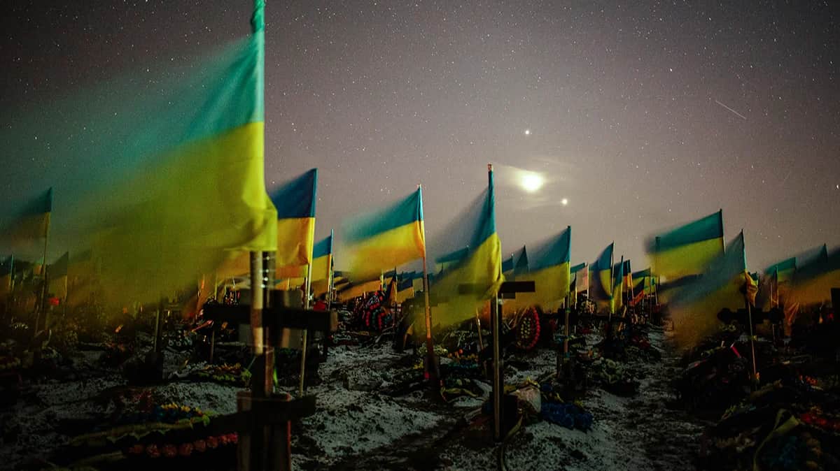 Украинские государственные флаги, развевающиеся над могилами павших украинских солдат на военном кладбище в Харькове в конце 22 февраля 2023 года. Фото: Pavlo Pakhomenko / EPA-EFE