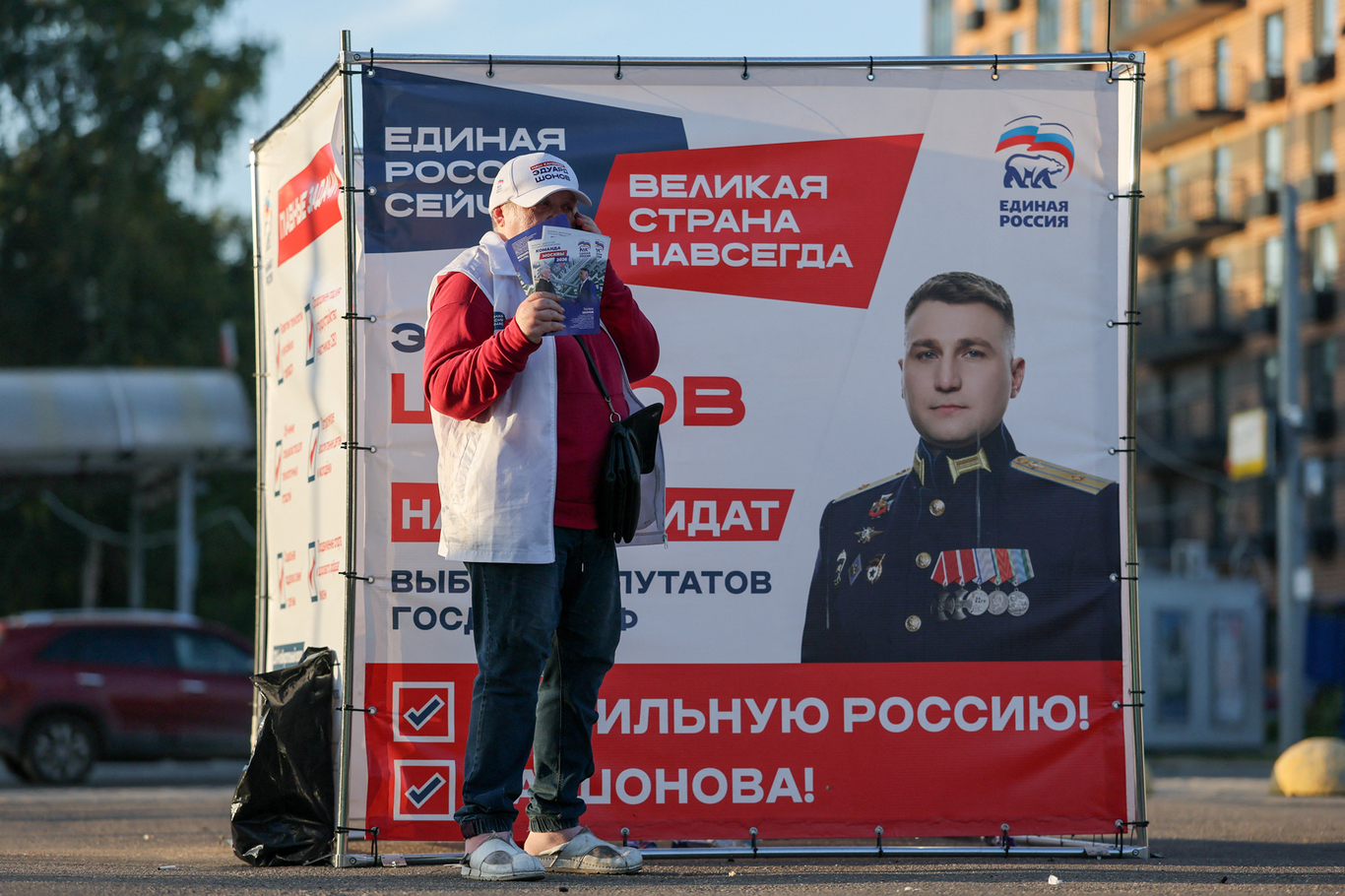 Агитатор раздает листовки прохожим возле палатки с портретом кандидата в депутаты Госдумы РФ от партии «Единая Россия» Эдуарда Шонова. Москва. 10 сентября 2026 года. Фото: Рамиль Ситдиков / Reuters / Scanpix / LETA