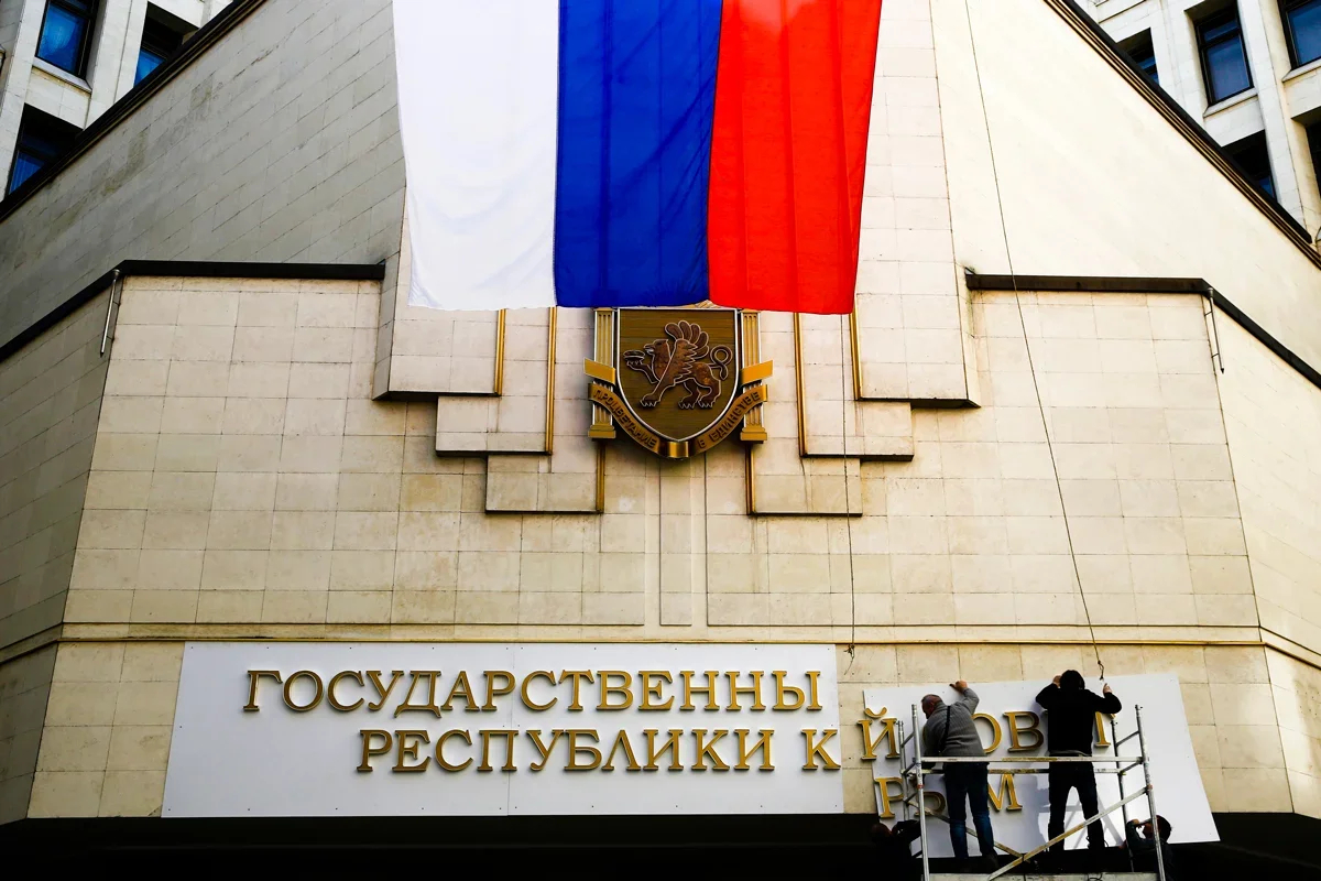 Workers put up new sign on administrative building in Simferopol, 19 March 2014. Photo: Thomas Peter / Reuters / Scanpix / LETA