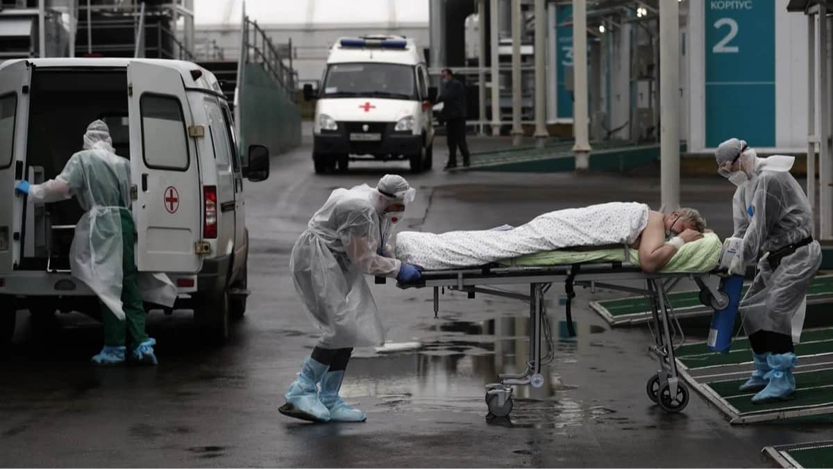 <span>Медики сопровождают пациента с COVID-19 на территории больничного комплекса в Коммунарке. Москва, 5 ноября 2021 года. Фото: Максим Шипенков / EPA</span>