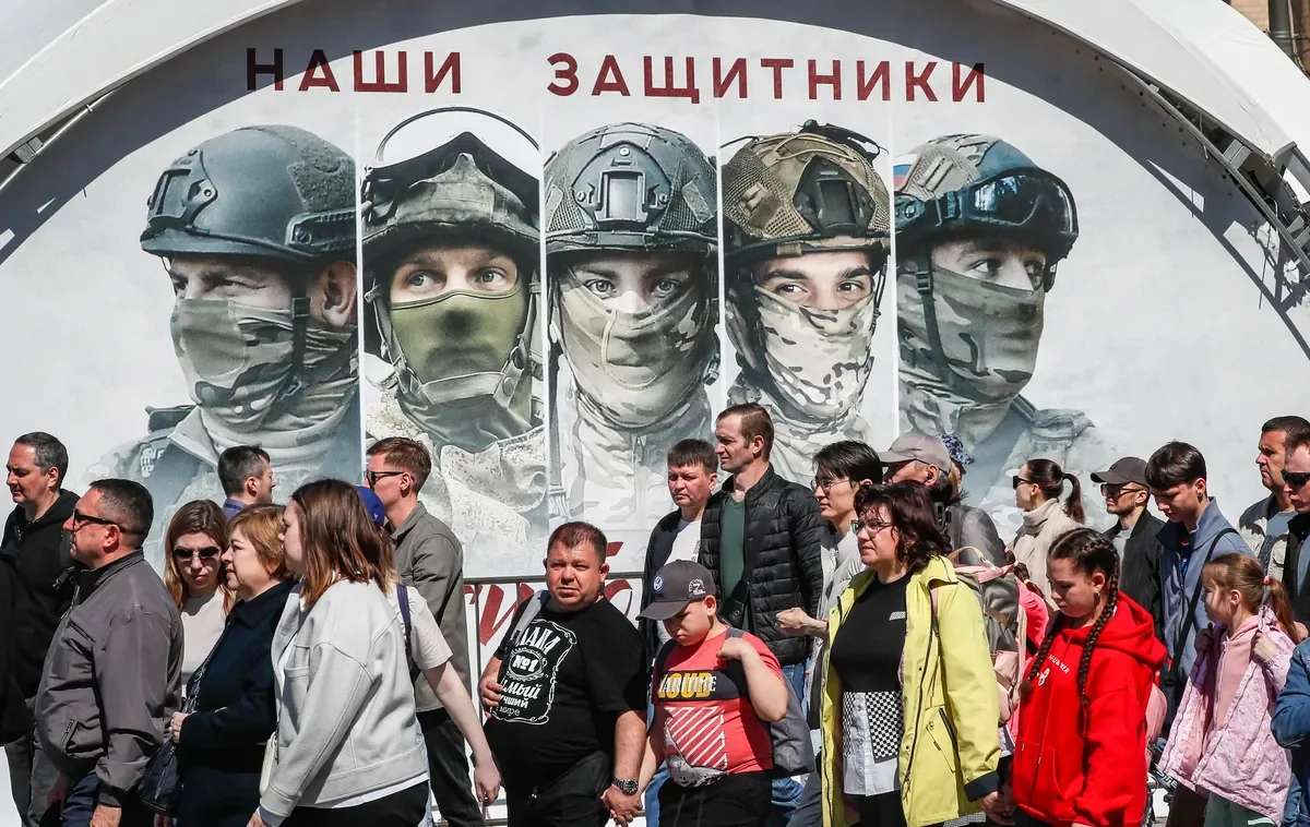 People stand near images of Russian soldiers and the inscription “Our Defenders” at an exhibition of weapons seized by the Russian Army during Russia’s “special military operation” in Ukraine, on the Poklonnaya Hill in Moscow, 01 May 2024. Photo: EPA-EFE/YURY KOCHETKOV