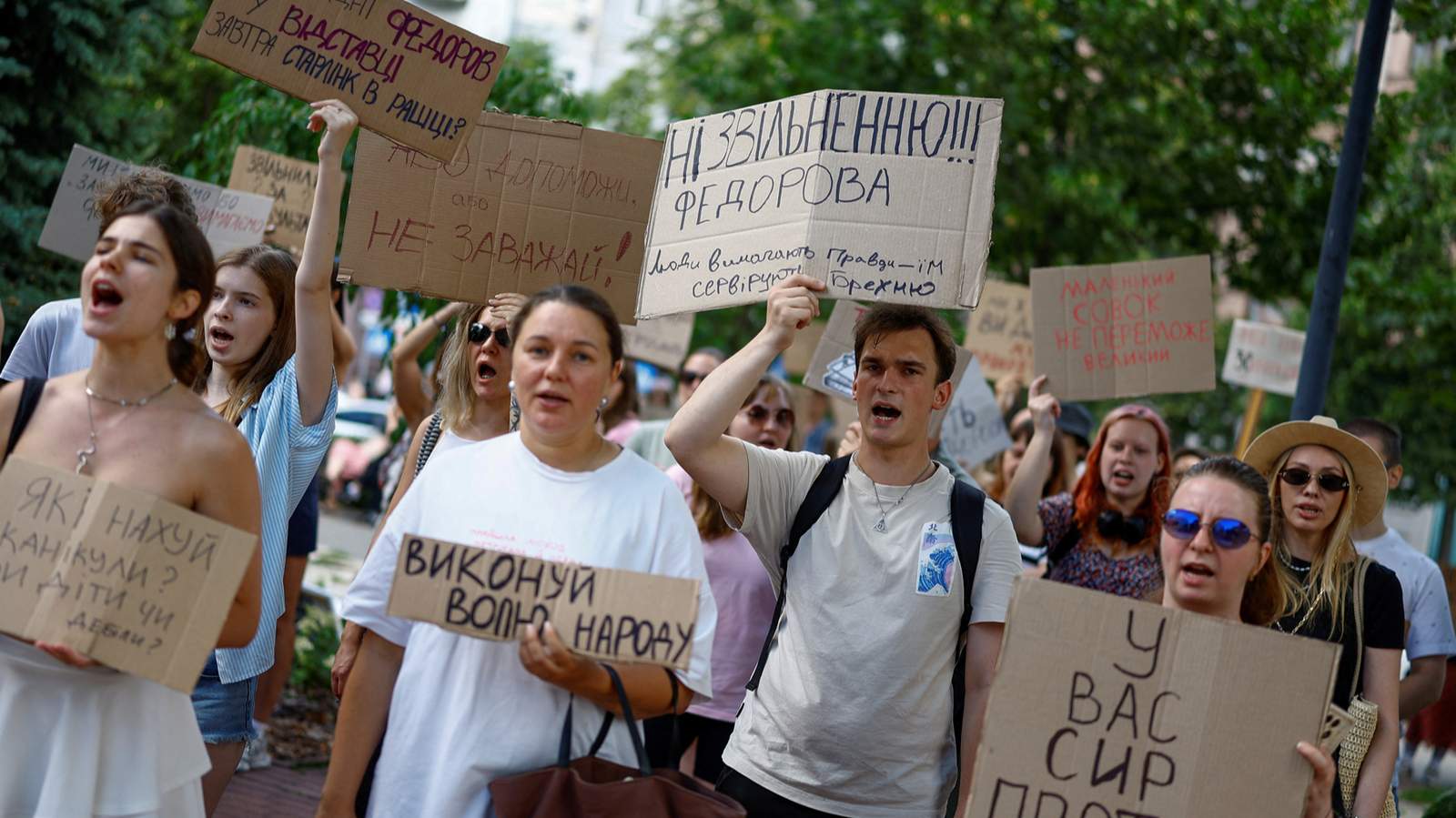 Участники акции протеста держат плакаты и скандируют лозунги против решения президента Украины Владимира Зеленского сменить Михаила Федорова на посту министра обороны и с требованием отставки главнокомандующего Вооруженными силами Украины Александра Сырского, Киев, Украина, 17 июля 2026 года. Фото: Valentyn Ogirenko / Reuters / Scanpix / LETA<br>