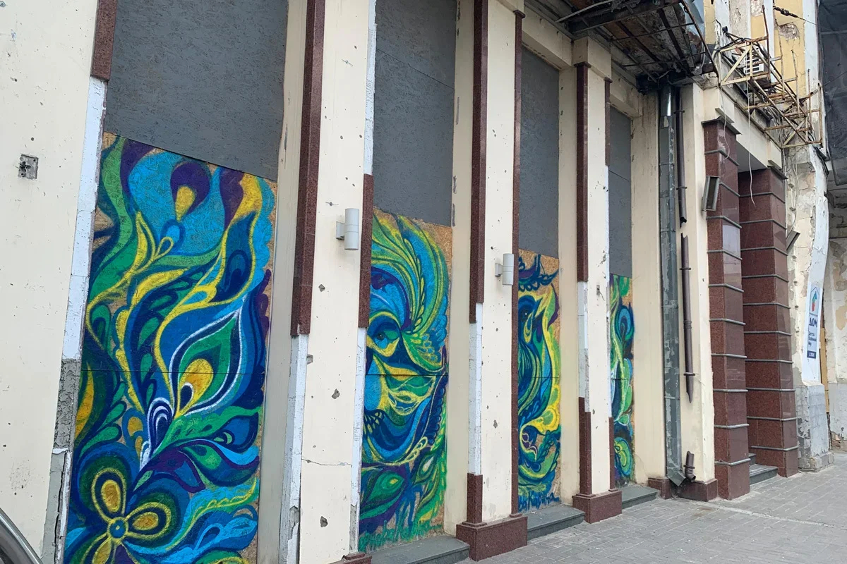 Plywood covers for blown-out windows have been turned into art objects in the centre of Kharkiv. Photo: Olga Musafirova / Novaya Gazeta Europe