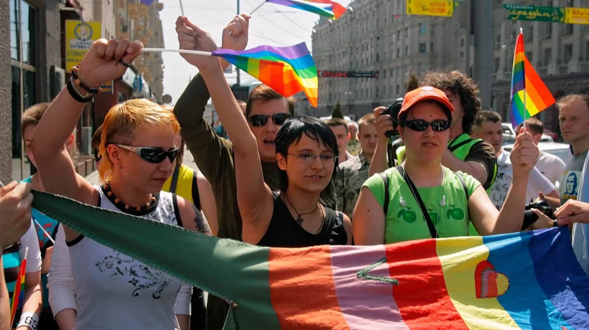 Участники гей-парада в Москве размахивают радужными флагами возле здания мэрии, запрещенного мэром Москвы Юрием Лужковым, 27 мая 2007 года. Фото: Сергей Ильницкий / EPA