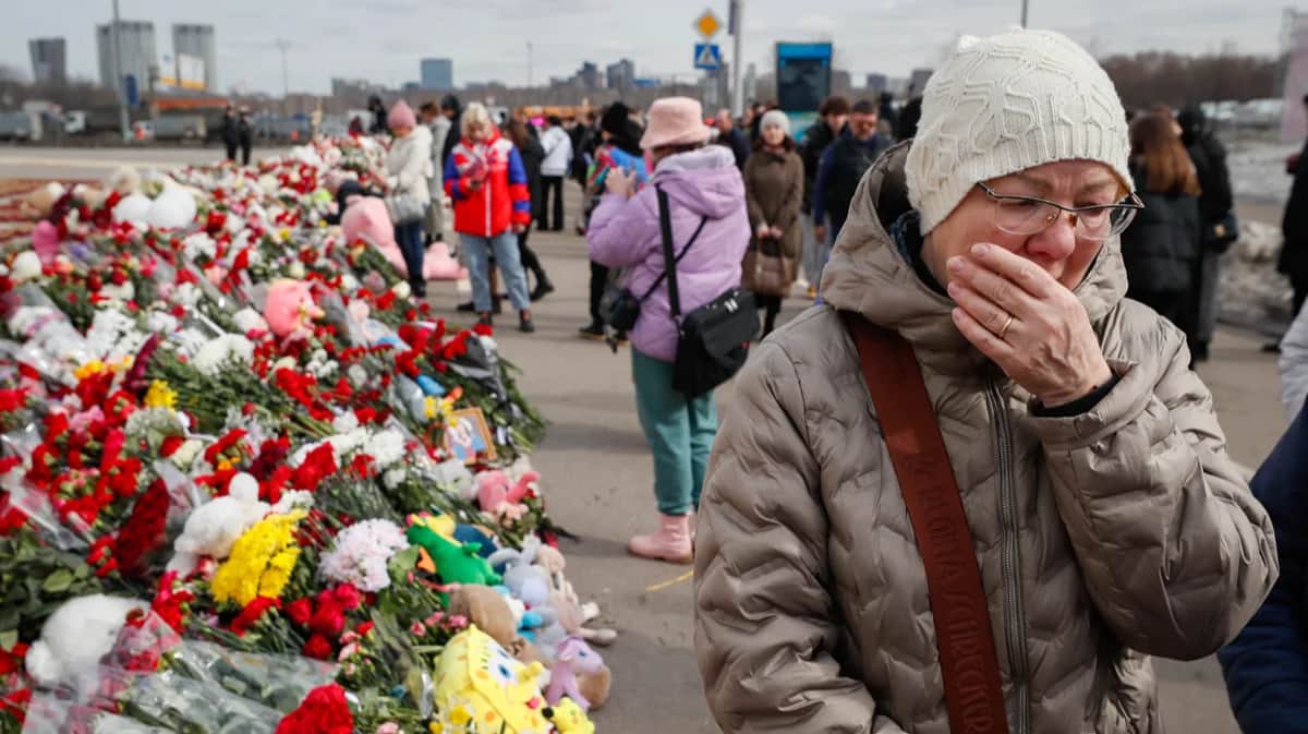 Женщина скорбит возле концертного зала «Крокус Сити Холл» после теракта, 26 марта 2024 года. Фото: Юрий Кочетков / EPA-EFE