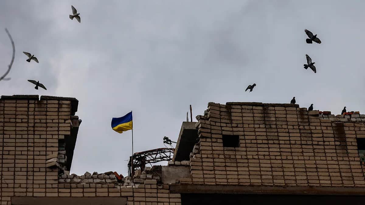 Украинский флаг над разрушенным зданием учебного заведения на севере Херсонской области, 6 ноября 2022 года. Фото: Hannibal Hanschke / EPA-EFE