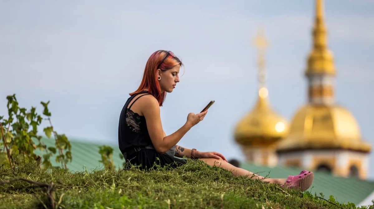Девушка с телефоном на фоне церкви в Суздале, 23 августа 2024 года. Фото: Максим Шеметов / Reuters / Scanpix / LETA