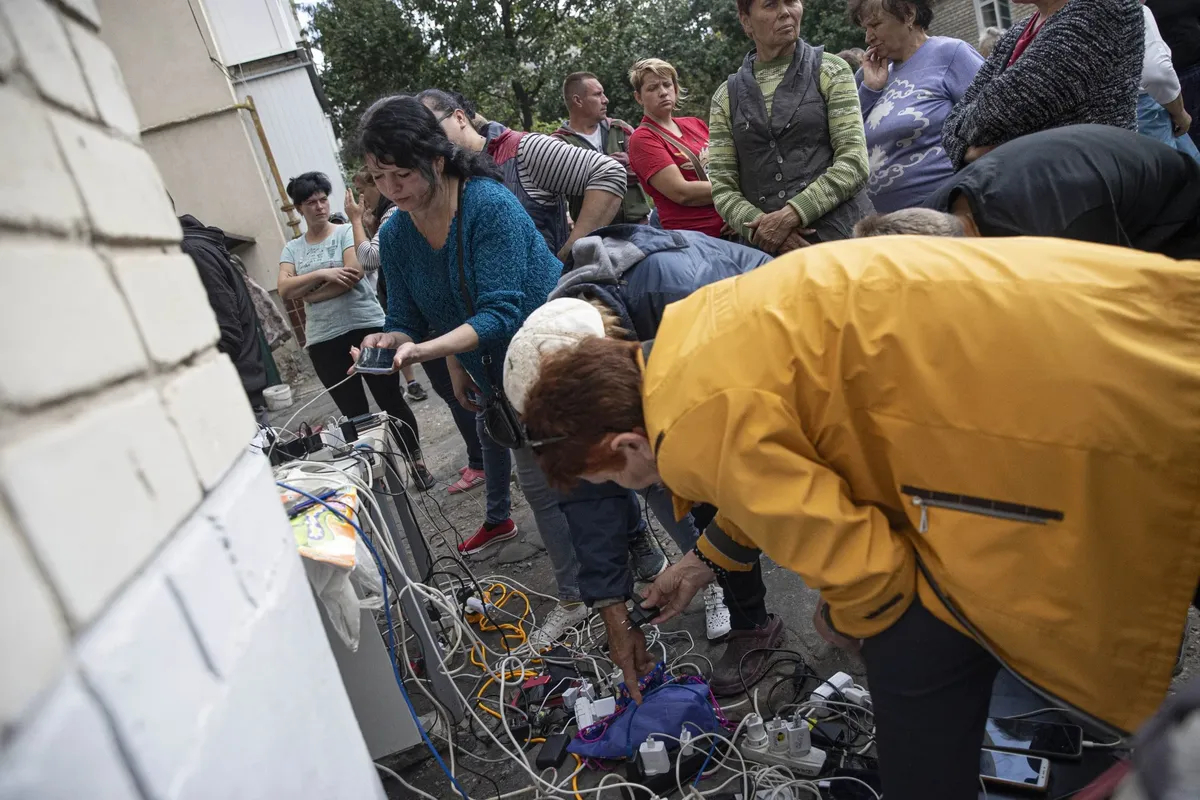 Izyum residents charge their phones using a diesel generator. 18 September 2022. Photo: Metin Aktas / Anadolu Agency / Getty Images