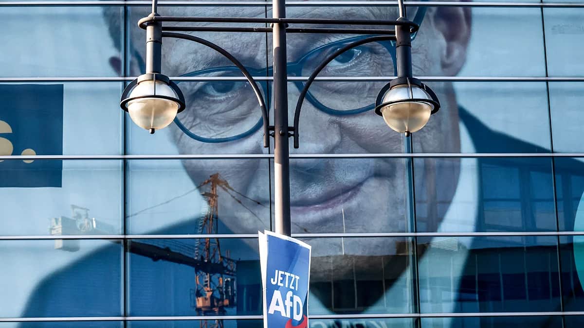 Плакат партии «Альтернатива для Германии» (AfD) на фонаре напротив масштабного предвыборного плаката председателя Христианско-демократического союза Германии (ХДС) Фридриха Мерца, который можно увидеть в штаб-квартире ХДС, доме Конрада Аденауэра, в Берлине, 13 января 2025 года. Фото: Filip Singer / EPA-EFE