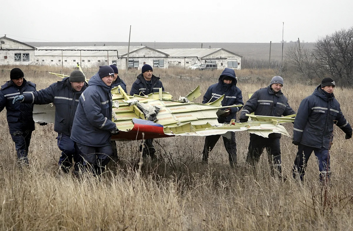 Рабочие разбирают части обломков пассажирского самолета MH17 авиакомпании Malaysia Airlines на месте крушения в селе Грабово, примерно в 70 км от Донецка, Украина, 18 ноября 2014 года. Фото: Alexander Ermochenko / EPA