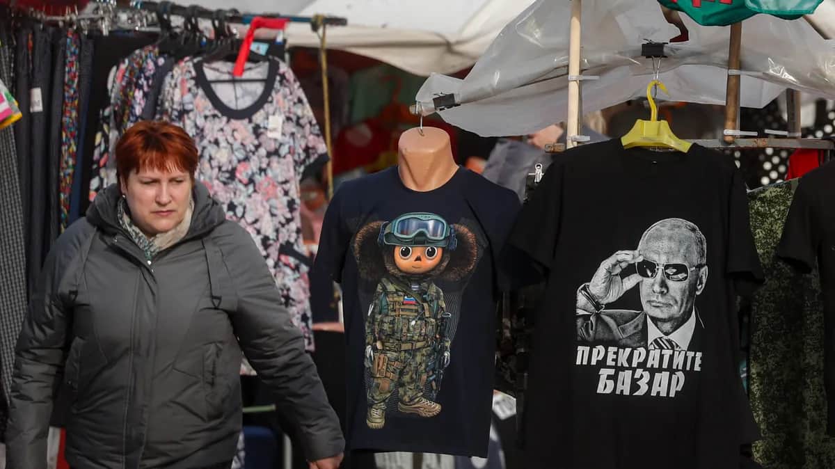 A woman walks past a stall selling “patriotic” shirts, including one with a portrait of Vladimir Putin and the slogan “Stop talking” in the Tula region town of Yefremov, Russia, 6 April 2023. Photo: EPA-EFE / MAXIM SHIPENKOV
<br>