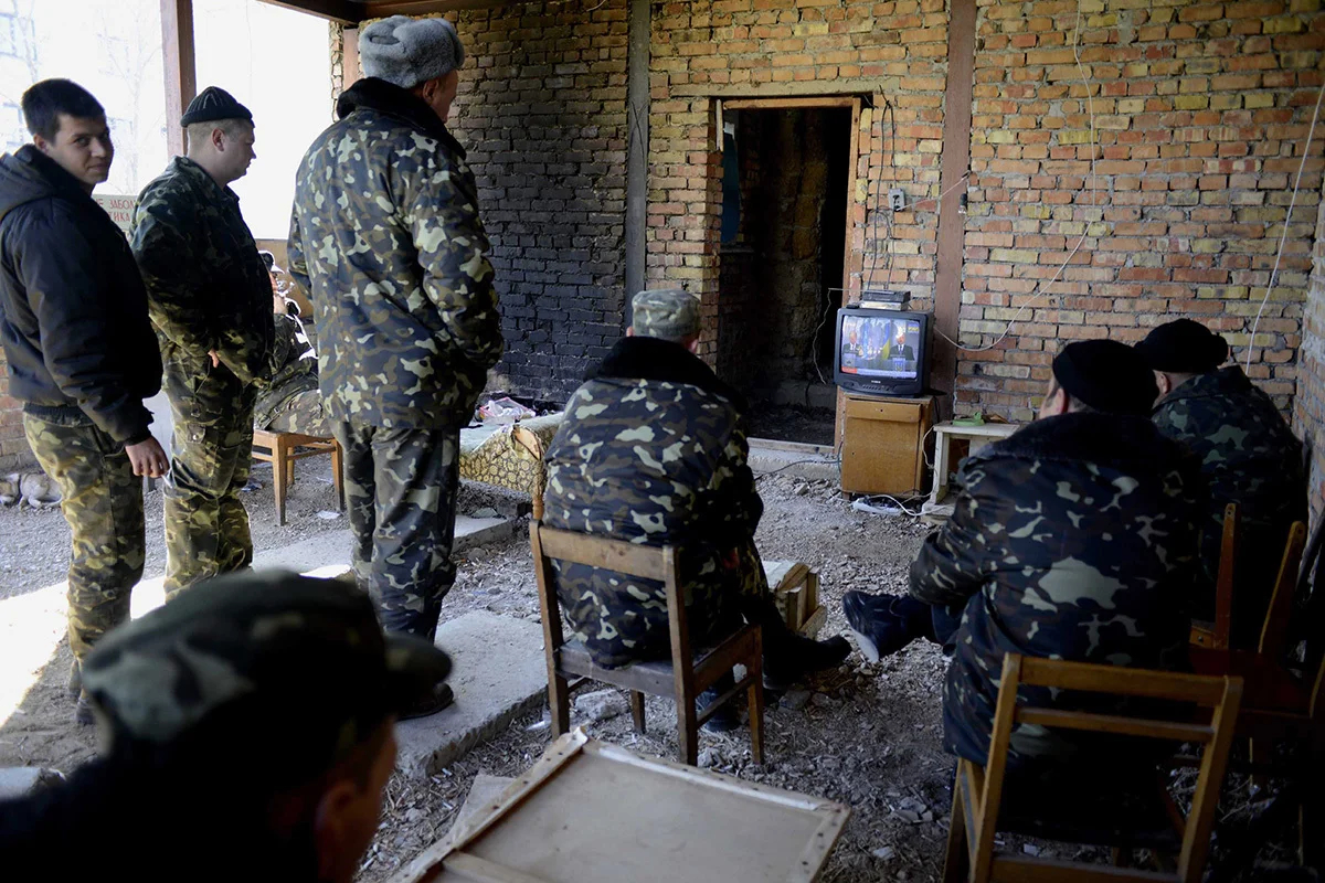 Украинские военные на последней украинской военной базе, которая не сдалась после аннексии Крыма, смотрят новости, ожидая приказа из Киева, Бельбек, Крым, Украина, 21 марта 2014 года. Фото: Jakub Kaminski / EPA