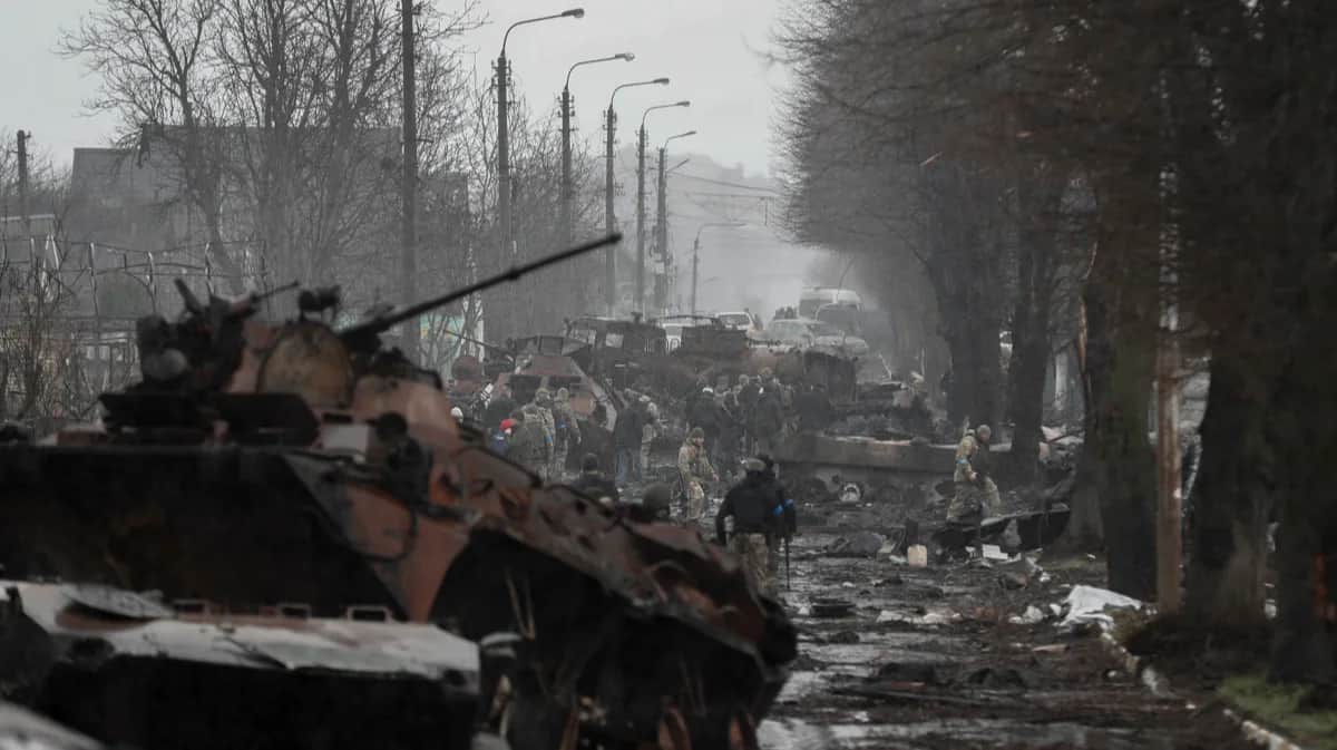 Украинские солдаты осматривают уничтоженную российскую военную технику в городе Буча, Украина, 3 апреля 2022 года. Фото: Atef Safadi / EPA-EFE