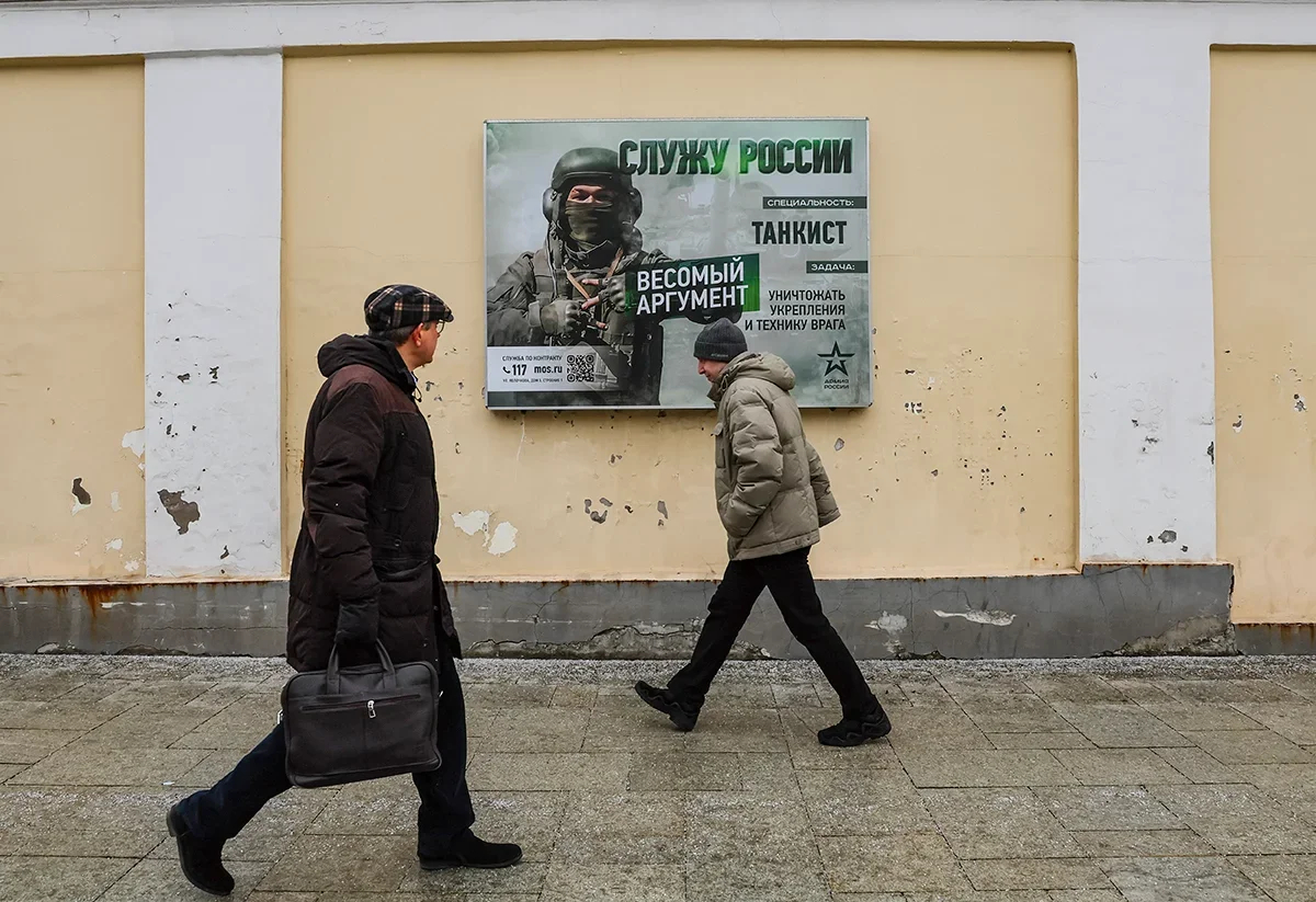People walk past a propaganda poster praising the Russian Armed Forces in Moscow, 20 February 2025. Phoro: EPA-EFE / YURI KOCHETKOV