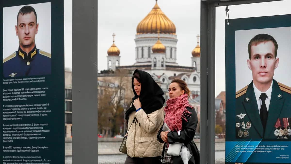 Russian women walk past pictures of servicemen who fought in Ukraine during a street exhibition in Moscow, October 2022. Photo: EPA-EFE/YURI KOCHETKOV