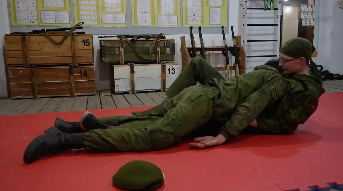Schoolchildren in the classroom at the Sarma club are practicing the evacuation of the bodies of the dead. <a href="https://www.youtube.com/watch?v=NjrPBmXX3vo" rel="noopener noreferrer" title="https://www.youtube.com/watch?v=NjrPBmXX3vo">A shot from the film “Firewood for the mobilised”</a>