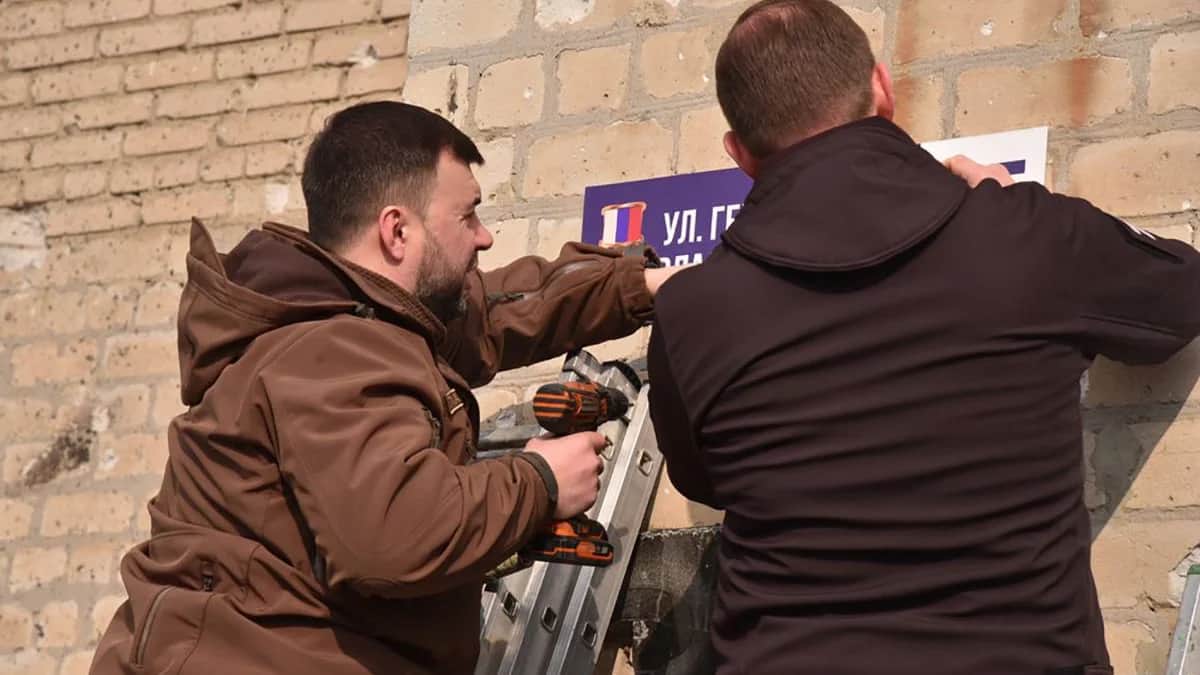 Андрей Турчак и Денис Пушилин прикрепляют таблицу с новым названием улицы в Волновахе. Фото: <a href="https://er.ru/activity/news/andrej-turchak-i-glava-dnr-denis-pushilin-otkryli-ulicu-imeni-kombata-sparty-vladimira-zhogi-v-osvobozhdennoj-volnovahe">Единая Россия</a>