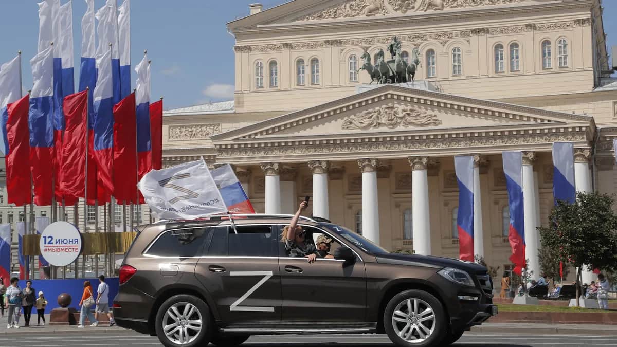 Автомобиль с российским флагом едет по улице перед Большим театром. Фото: EPA-EFE/MAXIM SHIPENKOV