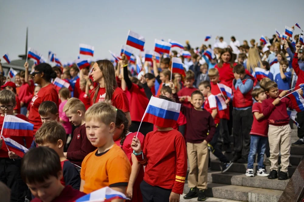 Members of various Russian youth organisations wave Russian flags to mark National Flag Day in Moscow, 22 August 2025. Photo: EPA/SERGEI ILNITSKY