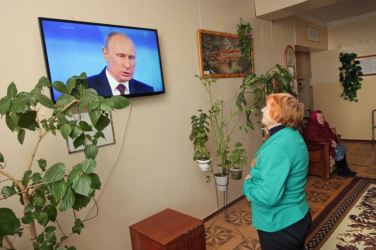 Пенсионерка в доме престарелых в Симферополе смотрит выступление Владимира Путина во время ежегодного прямого эфира, 17 апреля 2014 года. Фото: Артур Шварц / EPA