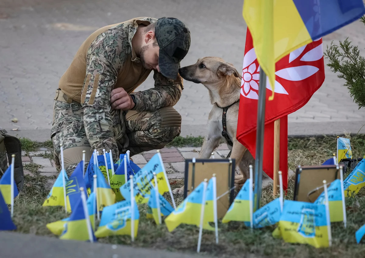 Военный у импровизированного мемориала с украинскими флагами и именами павших воинов на Майдане Независимости, Киев, 24 августа 2024 года. Фото: Gleb Garanich / Reuters / Scanpix / LETA