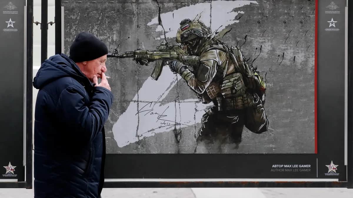 A man walks past a picture forming part of a military exhibition in St. Petersburg, 18 March 2024. Photo: EPA-EFE/ANATOLY MALTSEV