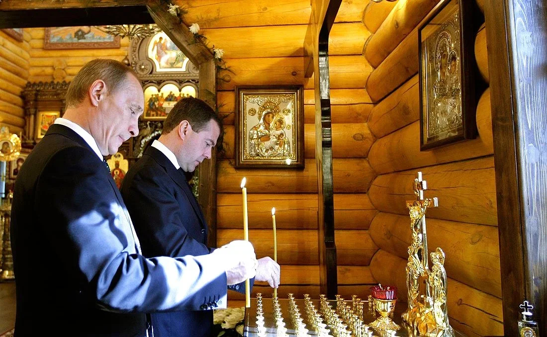 Vladimir Putin and Dmitry Medvedev light candles in a chapel on the territory of the presidential residence to honour those killed in the Smolensk plane crash. Photo: <a href="https://commons.wikimedia.org/w/index.php?curid=9974118" rel="noopener noreferrer" title="https://commons.wikimedia.org/w/index.php?curid=9974118">Wikimedia Commons</a>, CC BY 4.0