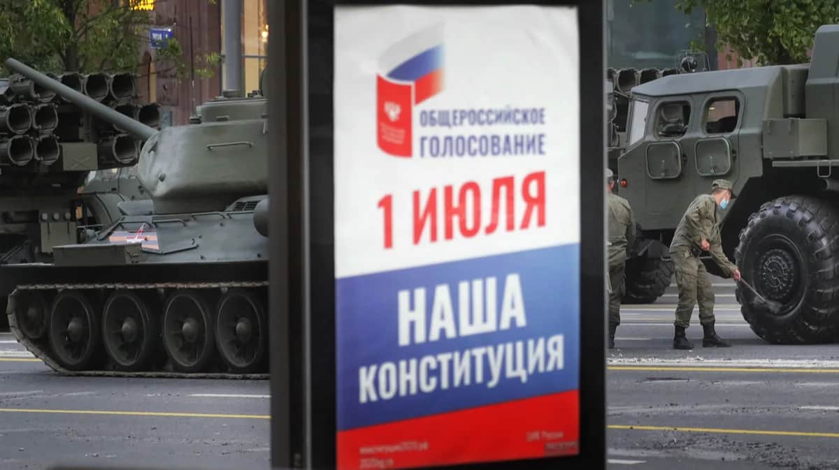 Плакат с рекламой голосования за изменения в Конституцию РФ на фоне танков во время подготовки к репетиции военного парада, Москва, 17 июня 2020 года. Фото: Максим Шипенков / EPA