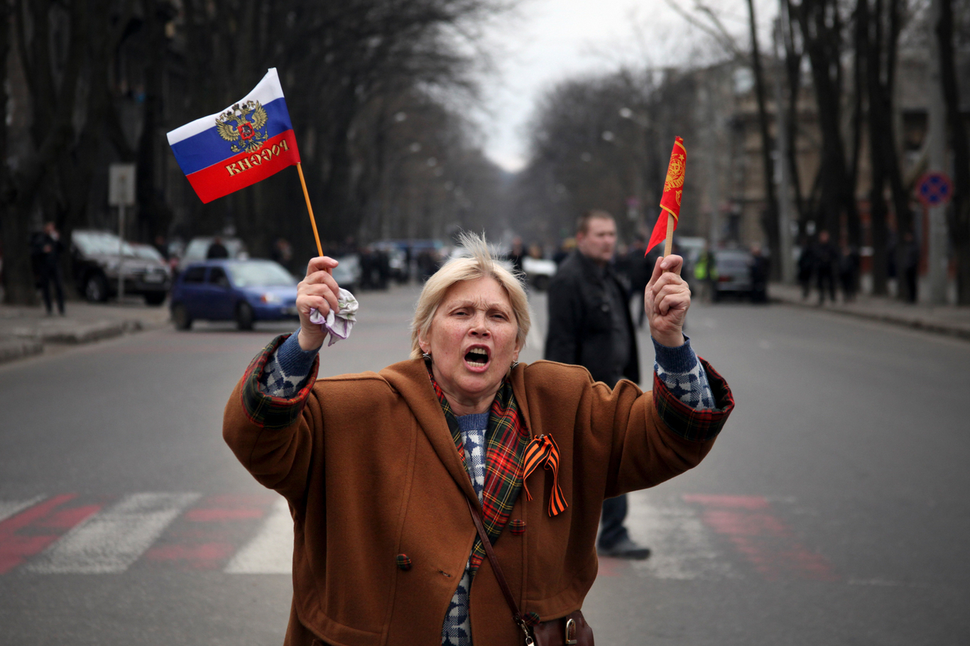 Пророссийская активистка размахивает флагами России и СССР во время митинга против узурпации власти и политических репрессий. Одесса, Украина. 23 марта 2014 года. Фото: Sergei Poliakov / AP / Scanpix / LETA