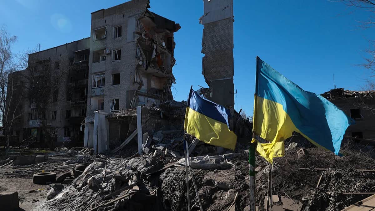 Украинские флаги развеваются перед поврежденными жилыми зданиями в Орехове, недалеко от линии фронта в Запорожской области, на юго-востоке Украины, 28 февраля 2024 года. Фото: Катерина Клочко / EPA-EFE