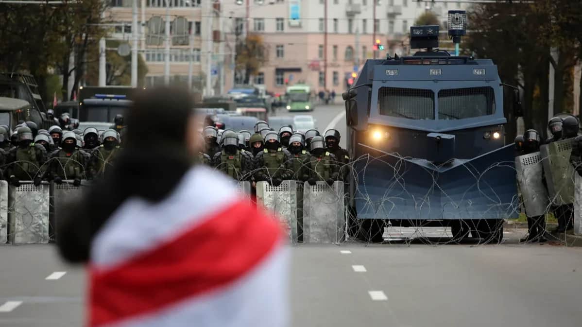 A protester stands in front of Belarusian police blocking the road at an anti-government rally in Minsk, Belarus, 25 October 2020. Photo: EPA