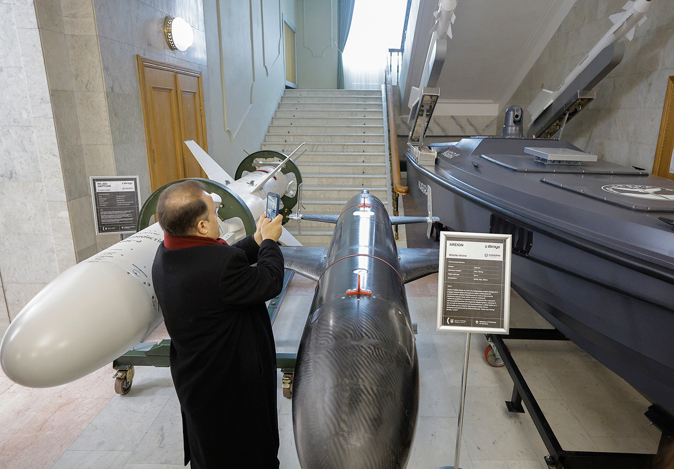 Посетители осматривают крылатую ракету RK-360 «Нептун», ракетный беспилотник «Ареон» и морской беспилотник Magura V7 в Киеве, Украина, 13 апреля 2026 года. Фото: Sergey Dolzhenko / EPA