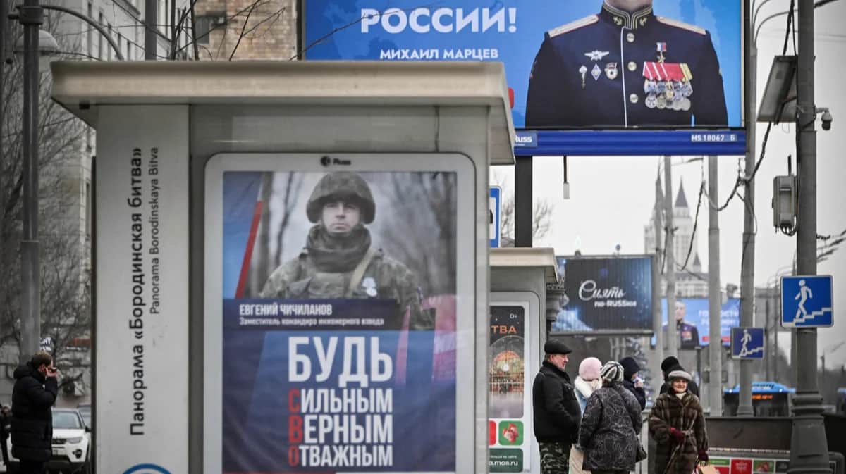 Прохожие на фоне пропагандистских плакатов и рекламы контрактной службы, Москва, 22 января 2025 года. Фото: Александр Неменов / AFP / Scanpix / LETA