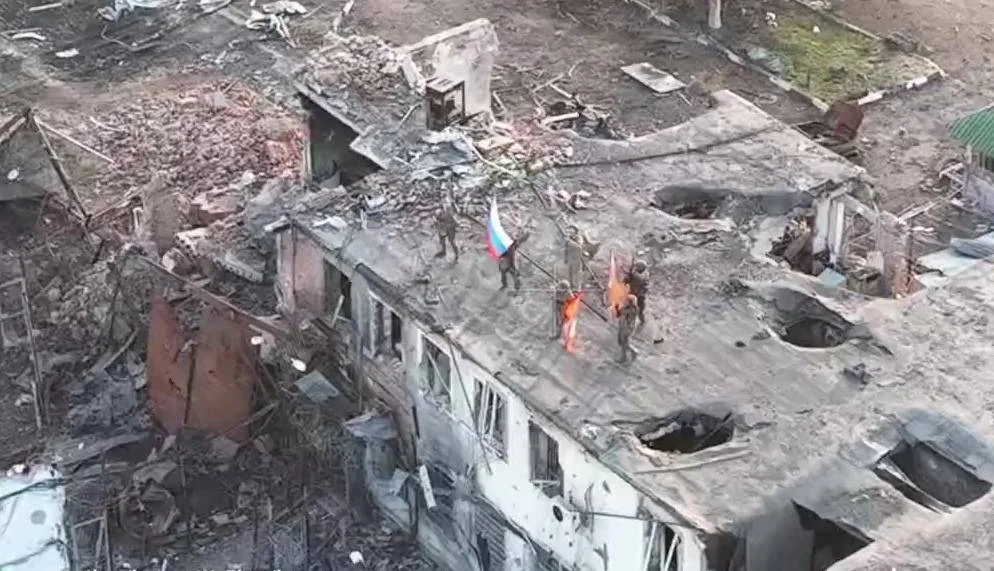 Российские военнослужащие поднимают флаги на здании в Малой Локне, Курская область, 9 марта 2025 года. Кадр из видео Минобороны России