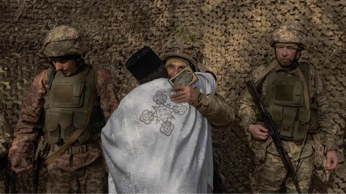 Священник и военнослужащие ВСУ во время молитвы в честь Пасхи в Харьковской области, Украина, 12 апреля 2026 года. Фото: Roman Pilipey / AFP / Scanpix / LETA<br>