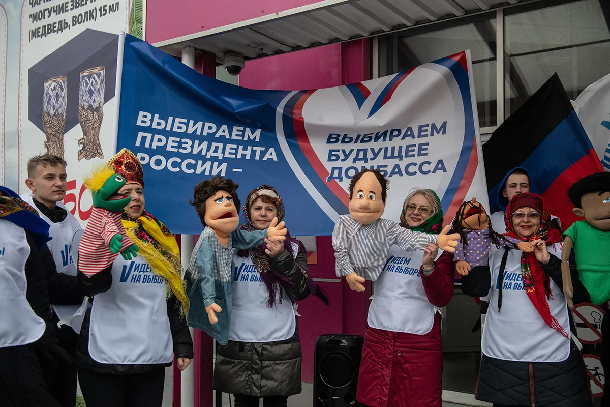 Волонтеры выступающие с куклами во время досрочного голосования на президентских выборах в России на улице в Донецке, контролируемой Россией части Украины, 13 марта 2024 года. Фото: Стрингер / EPA-EFE