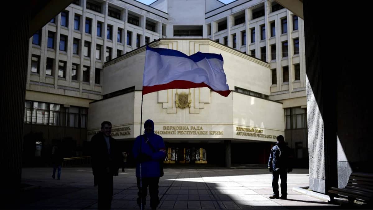 Люди с флагом Крыма перед зданием парламента в Симферополе, 17 марта 2014 года. Фото: Jakub Kaminski / EPA<br>