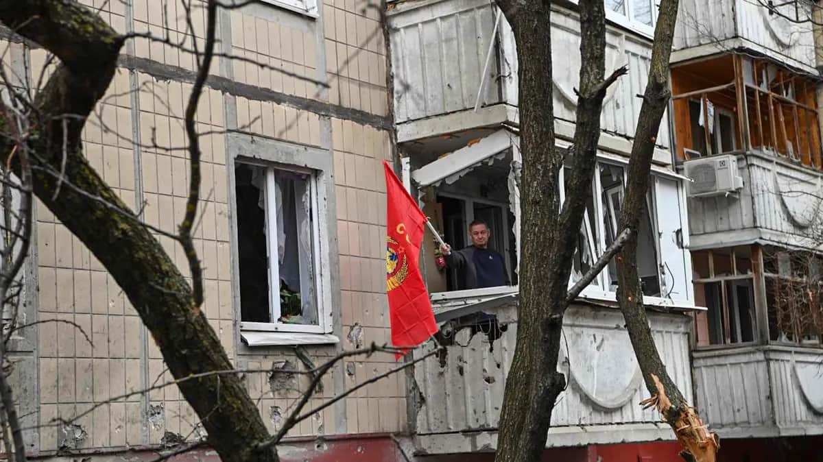 Мужчина машет красным флагом с балкона разрушенного после обстрела здания в центре Белгорода, 16 марта 2024 года. Фото: EPA-EFE / BELGOROD MAYOR