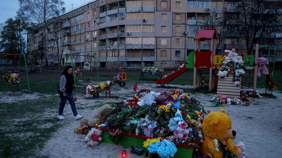 Женщина возлагает цветы на детскую площадку, где в результате ракетного удара погибли 20 человек, включая 9 детей, Кривой Рог, 7 апреля 2025 года. Фото: Evgeniy Maloletka / AP Photo / Scanpix / LETA
