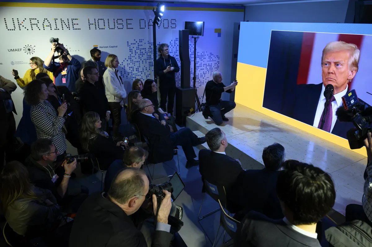 Delegates to the 55th World Economic Forum in Davos, Switzerland, watch the inauguration of Donald Trump, 20 January 2025. Photo: EPA-EFE / LAURENT GILLIERON