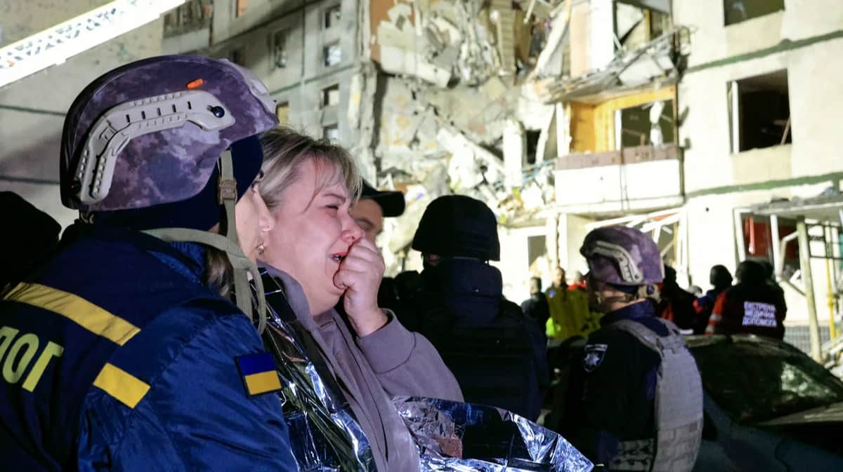 Жительница Харькова на фоне разрушенного российской бомбой жилого дома, Украина, 30 октября 2024 года. Фото: Sergey Kozlov / EPA