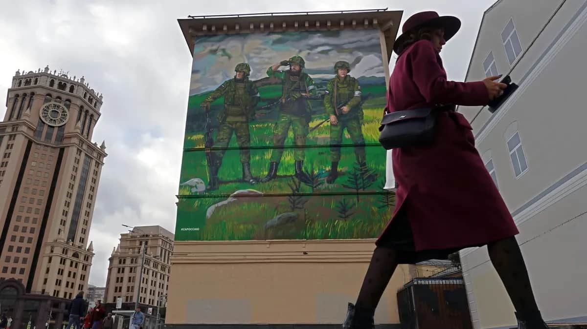 A woman walks past a mural in support of the Russian army on a building in Moscow, 20 September 2022. Photo: EPA-EFE/MAXIM SHIPENKOV